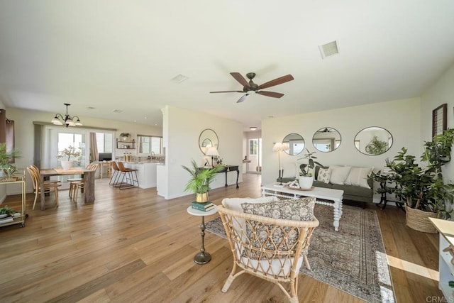 3890 Vista Campana S Unit 35, Oceanside, CA 92057 - living area with ceiling fan, light wood-style floors, and a chandelier