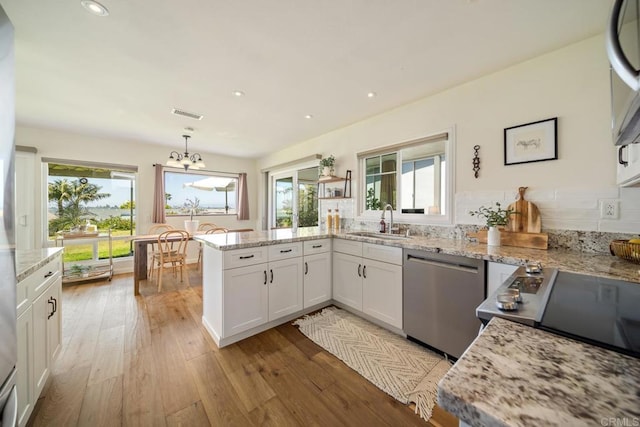 3890 Vista Campana S Unit 35, Oceanside, CA 92057 - kitchen featuring dishwasher, a sink, a chandelier, a peninsula, and light wood-style floors