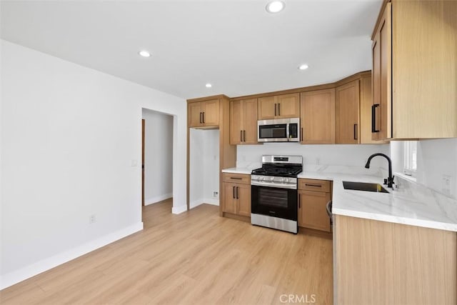 22306 Marlin Pl, Canoga Park, CA 91303 - kitchen with stainless steel appliances, a sink, light stone counters, light wood finished floors, and recessed lighting