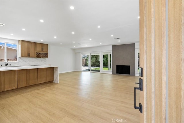 22306 Marlin Pl, Canoga Park, CA 91303 - unfurnished living room with a sink, recessed lighting, light wood-style flooring, a fireplace, and baseboards
