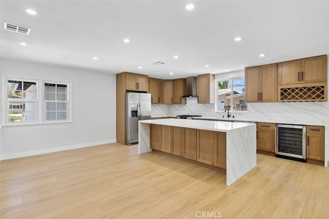 22306 Marlin Pl, Canoga Park, CA 91303 - kitchen featuring beverage cooler, stainless steel refrigerator with ice dispenser, a center island, tasteful backsplash, and wall chimney exhaust hood