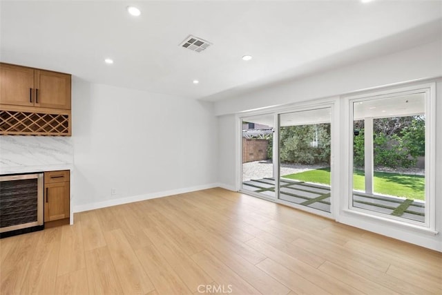 22306 Marlin Pl, Canoga Park, CA 91303 - unfurnished living room with wine cooler, a bar, light wood-type flooring, recessed lighting, and baseboards