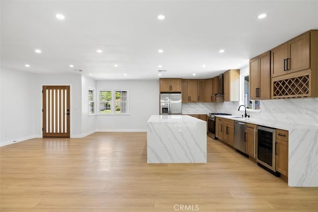 22306 Marlin Pl, Canoga Park, CA 91303 - kitchen with appliances with stainless steel finishes, beverage cooler, a kitchen island, recessed lighting, and light stone countertops