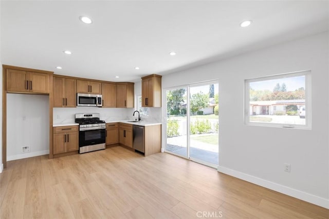 22306 Marlin Pl, Canoga Park, CA 91303 - kitchen with appliances with stainless steel finishes, a sink, light countertops, brown cabinetry, and recessed lighting