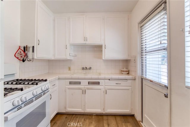 2107 Cyril Ave, Los Angeles, CA 90032 - kitchen with white gas range, a sink, white cabinetry, and tasteful backsplash