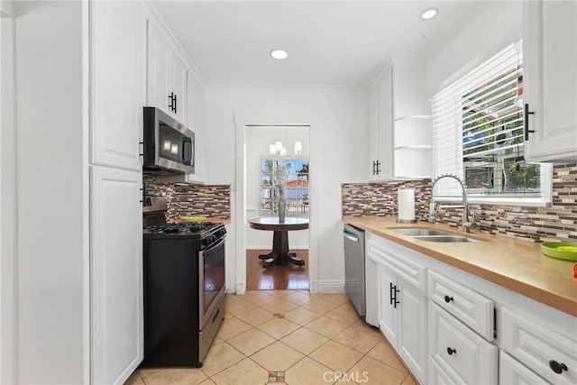 11900 Covello St, North Hollywood, CA 91605 - kitchen featuring stainless steel appliances, a sink, backsplash, white cabinetry, and light tile patterned flooring