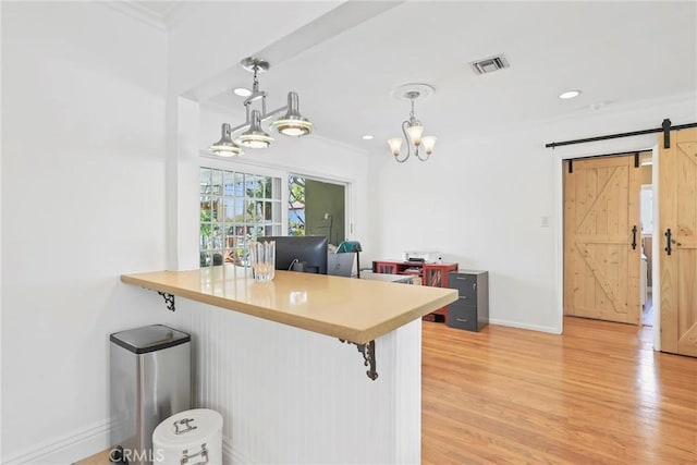 11900 Covello St, North Hollywood, CA 91605 - kitchen featuring a breakfast bar, a barn door, baseboards, light wood finished floors, and ornamental molding