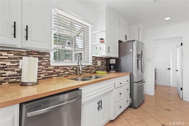 11900 Covello St, North Hollywood, CA 91605 - kitchen featuring appliances with stainless steel finishes, a sink, light tile patterned flooring, white cabinetry, and backsplash