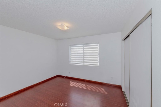 5021 Peck Rd Unit 9, El Monte, CA 91732 - unfurnished bedroom with wood finished floors, a closet, a textured ceiling, and baseboards