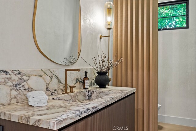 4625 Vesper Ave, Sherman Oaks, CA 91403 - bathroom with vanity, toilet, baseboards, and tasteful backsplash