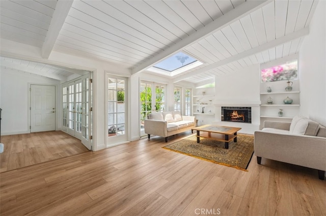 4950 Dunman Ave, Woodland Hills, CA 91364 - living room featuring a lit fireplace, wood finished floors, built in features, and a skylight
