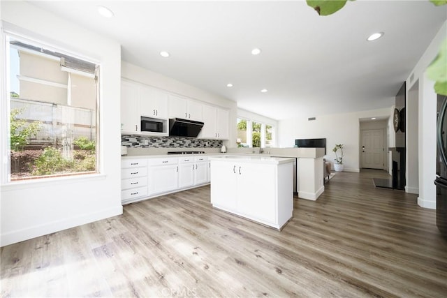 2902 Easton Pl, Rowland Heights, CA 91748 - kitchen with a kitchen island, white cabinets, light countertops, decorative backsplash, and built in microwave