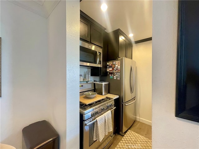 10960 Ashton Ave Unit 307, Los Angeles, CA 90024 - kitchen featuring appliances with stainless steel finishes, crown molding, light wood-type flooring, and light countertops