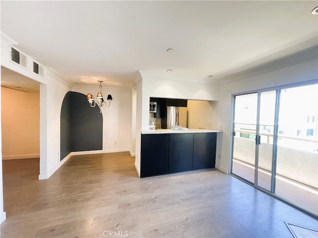 10960 Ashton Ave Unit 307, Los Angeles, CA 90024 - kitchen featuring freestanding refrigerator, a chandelier, dark cabinets, light wood finished floors, and crown molding