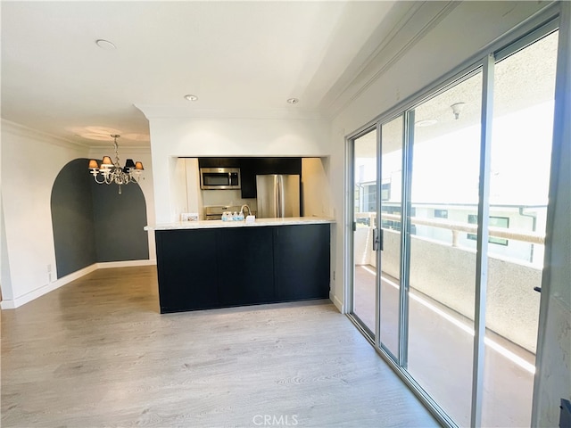 10960 Ashton Ave Unit 307, Los Angeles, CA 90024 - kitchen with stainless steel appliances, a chandelier, crown molding, light wood finished floors, and light countertops