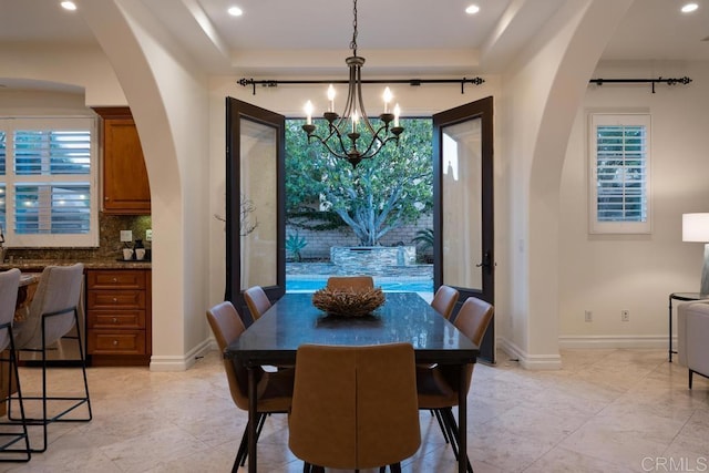 7845 Caminito Camelia, San Diego, CA 92127 - dining space with arched walkways, a chandelier, a tray ceiling, recessed lighting, and light tile patterned floors