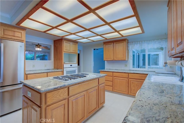 1375 San Gabriel Way, Merced, CA 95340 - kitchen featuring appliances with stainless steel finishes, a center island, a ceiling fan, light stone counters, and a sink