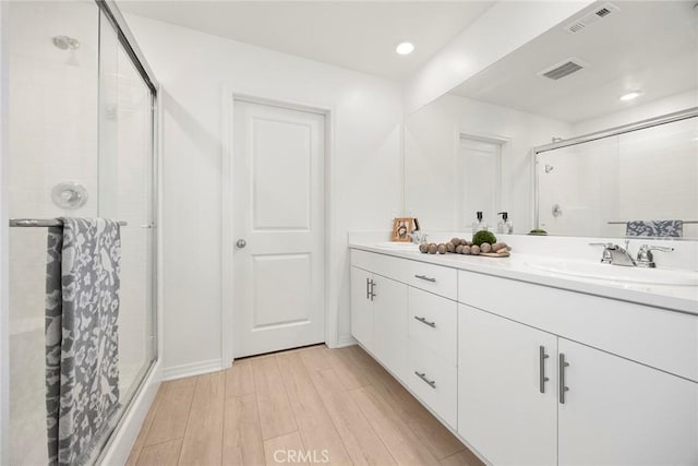 2544 Gunner Ridge Way, Rialto, CA 92377 - bathroom featuring a stall shower, double vanity, wood finished floors, and recessed lighting