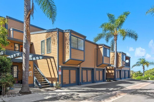 801 Kalpati Cir Unit B, Carlsbad, CA 92008 - view of property with an attached garage, stairs, and asphalt driveway