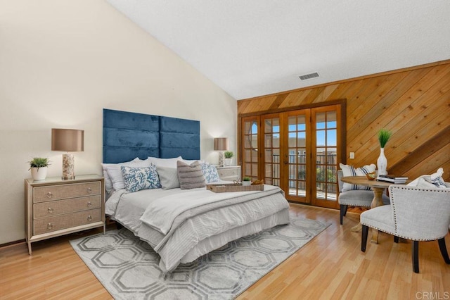 801 Kalpati Cir Unit B, Carlsbad, CA 92008 - bedroom featuring french doors, wood walls, wood finished floors, access to exterior, and high vaulted ceiling