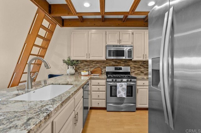 801 Kalpati Cir Unit B, Carlsbad, CA 92008 - kitchen featuring stainless steel appliances, a sink, light wood-style floors, coffered ceiling, and tasteful backsplash