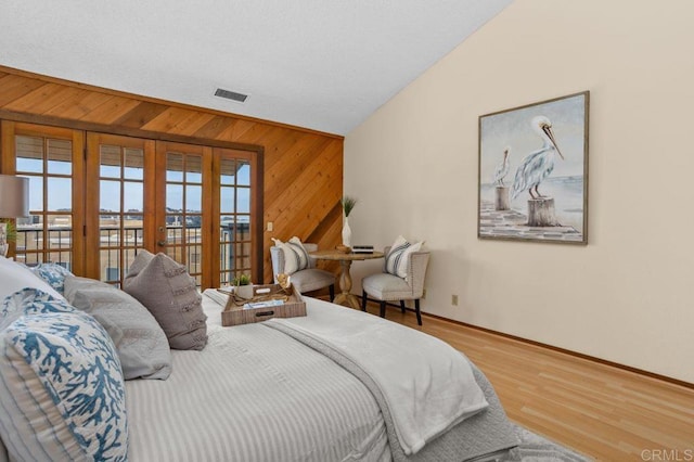 801 Kalpati Cir Unit B, Carlsbad, CA 92008 - bedroom featuring french doors, wooden walls, access to exterior, lofted ceiling, and baseboards