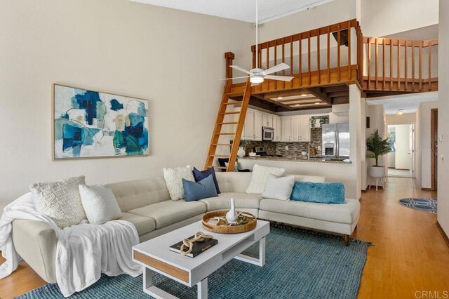 801 Kalpati Cir Unit B, Carlsbad, CA 92008 - living room featuring light wood-style floors, ceiling fan, and a high ceiling