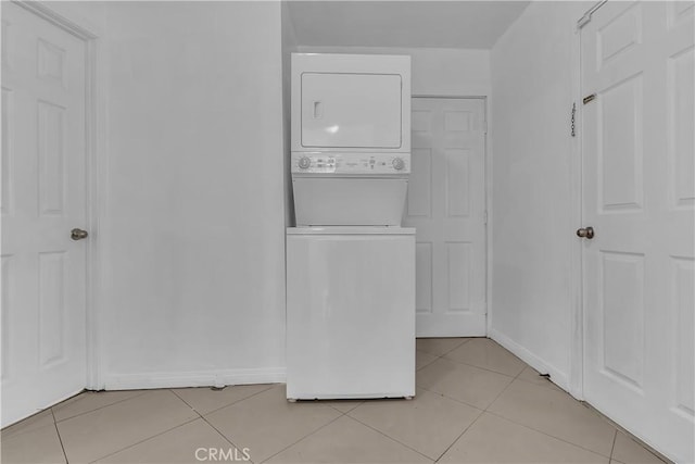 1144 Magnolia Ave, Gardena, CA 90247 - laundry area with stacked washer / drying machine, light tile patterned flooring, and baseboards