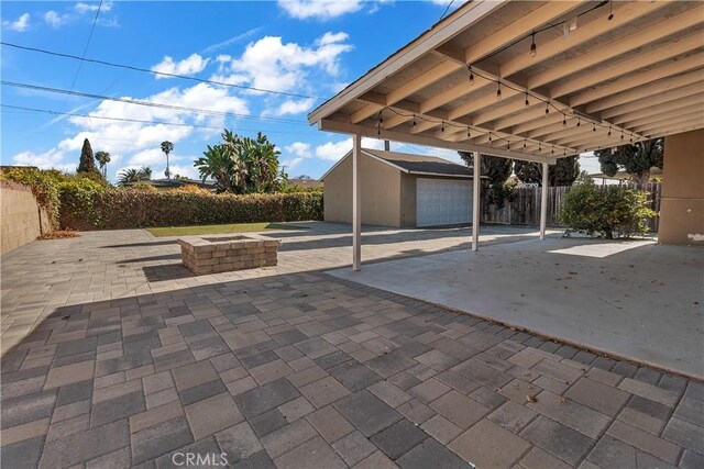 1144 Magnolia Ave, Gardena, CA 90247 - view of patio featuring an outdoor structure, a garage, and a fire pit