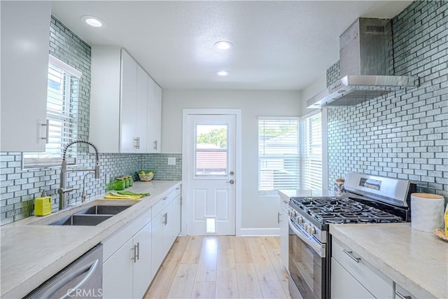 417 E 44th Way, Long Beach, CA 90807 - kitchen with appliances with stainless steel finishes, a sink, wall chimney exhaust hood, light wood-style floors, and light countertops