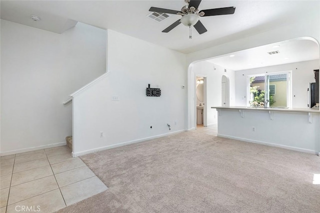 1587 N Strada Way, Clovis, CA 93619 - unfurnished living room featuring arched walkways, ceiling fan, light carpet, and light tile patterned floors