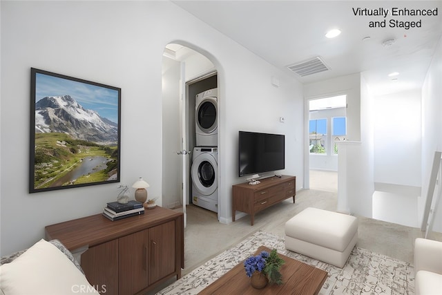 1587 N Strada Way, Clovis, CA 93619 - living room with estacked washer and dryer, arched walkways, light colored carpet, and recessed lighting