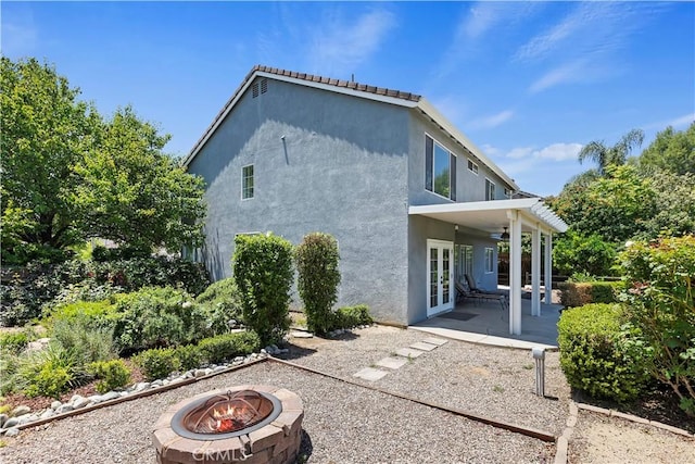 1825 Duncan Way, Corona, CA 92881 - back of house featuring french doors, an outdoor fire pit, stucco siding, a patio area, and a ceiling fan