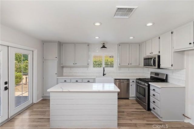 1825 Duncan Way, Corona, CA 92881 - kitchen with appliances with stainless steel finishes, a sink, backsplash, light wood-style floors, and recessed lighting