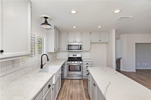 1825 Duncan Way, Corona, CA 92881 - kitchen with appliances with stainless steel finishes, light wood-type flooring, decorative backsplash, light stone counters, and recessed lighting