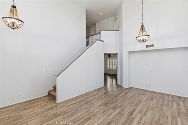 1825 Duncan Way, Corona, CA 92881 - unfurnished living room with a chandelier, wood finished floors, stairway, and a high ceiling