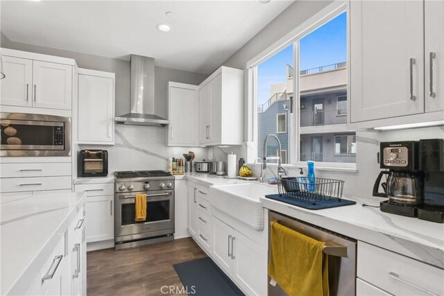 1639 Bridgewater Way, Costa Mesa, CA 92627 - kitchen featuring appliances with stainless steel finishes, wall chimney range hood, a sink, white cabinets, and dark wood-style flooring