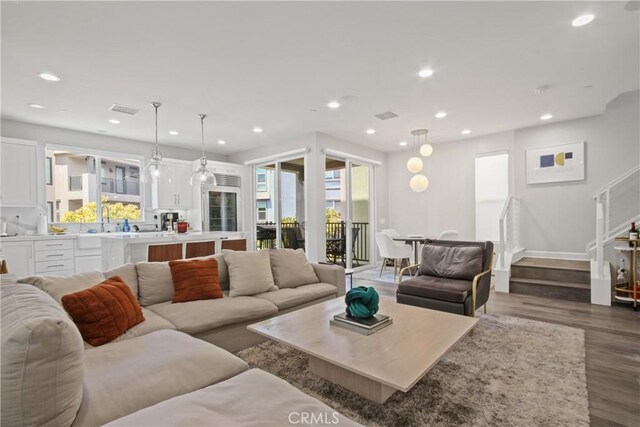 1639 Bridgewater Way, Costa Mesa, CA 92627 - living area featuring plenty of natural light, dark wood-style flooring, recessed lighting, stairs, and baseboards