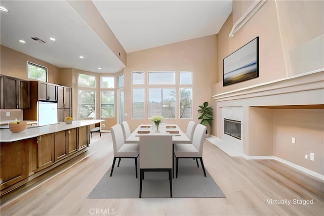 5338 S Chariton Ave, Ladera Heights, CA 90056 - dining space with light wood-type flooring, recessed lighting, baseboards, vaulted ceiling, and a premium fireplace