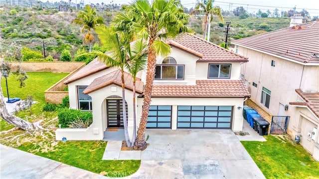 5338 S Chariton Ave, Ladera Heights, CA 90056 - mediterranean / spanish-style house with a tile roof, stucco siding, driveway, an attached garage, and a gate