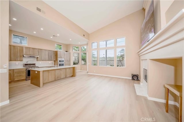 5338 S Chariton Ave, Ladera Heights, CA 90056 - kitchen featuring stainless steel range, high vaulted ceiling, light countertops, light wood-style floors, and open floor plan