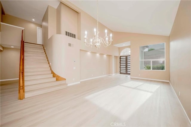 5338 S Chariton Ave, Ladera Heights, CA 90056 - unfurnished living room with stairs, a chandelier, baseboards, wood finished floors, and high vaulted ceiling