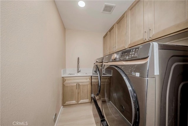 5338 S Chariton Ave, Ladera Heights, CA 90056 - laundry area featuring washer and clothes dryer, cabinet space, light wood finished floors, baseboards, and a textured wall