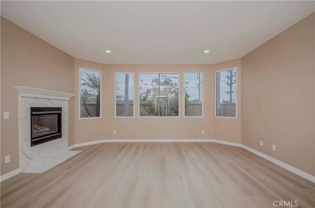 5338 S Chariton Ave, Ladera Heights, CA 90056 - unfurnished living room with healthy amount of natural light, light wood finished floors, baseboards, a high end fireplace, and recessed lighting
