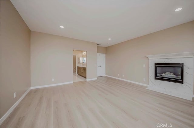 5338 S Chariton Ave, Ladera Heights, CA 90056 - unfurnished living room featuring light wood-style floors, baseboards, a high end fireplace, and recessed lighting