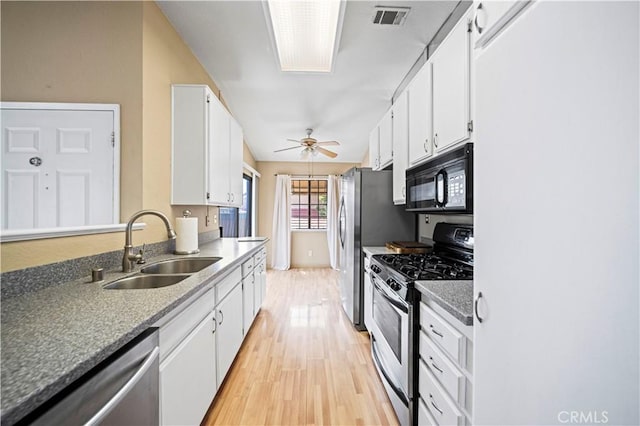 3501 W Greentree Cir Unit F, Anaheim, CA 92804 - kitchen with stainless steel appliances, a sink, light wood-type flooring, white cabinetry, and ceiling fan