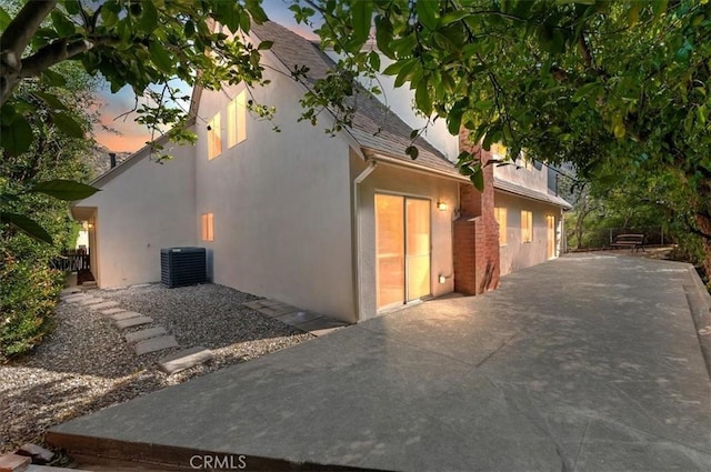770 Libby Dr, Riverside, CA 92507 - view of side of home with stucco siding, a patio area, central AC unit, and a shingled roof
