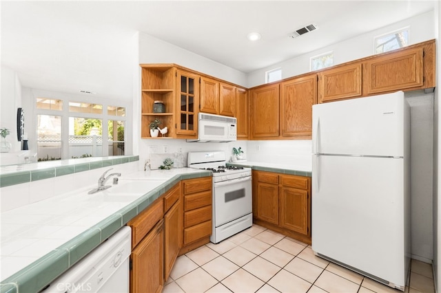 167 Iris Ln, Brea, CA 92821 - kitchen featuring white appliances, healthy amount of natural light, tile counters, brown cabinetry, and recessed lighting
