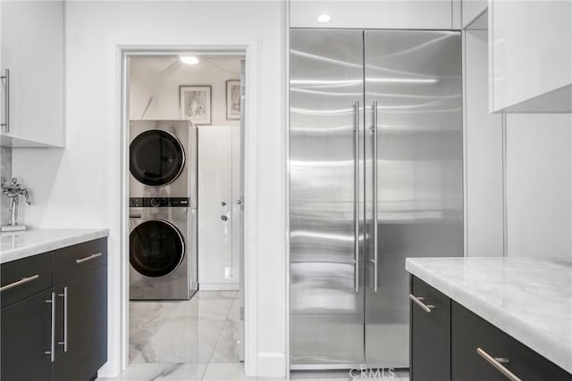 14347 Albers St Unit 207, Sherman Oaks, CA 91401 - kitchen with stainless steel built in fridge, stacked washer / drying machine, white cabinetry, and dark cabinets
