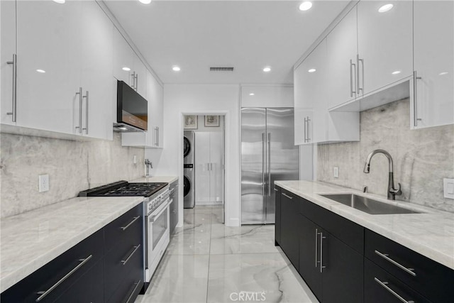 14347 Albers St Unit 207, Sherman Oaks, CA 91401 - kitchen with stacked washer / drying machine, high quality appliances, a sink, dark cabinetry, and modern cabinets